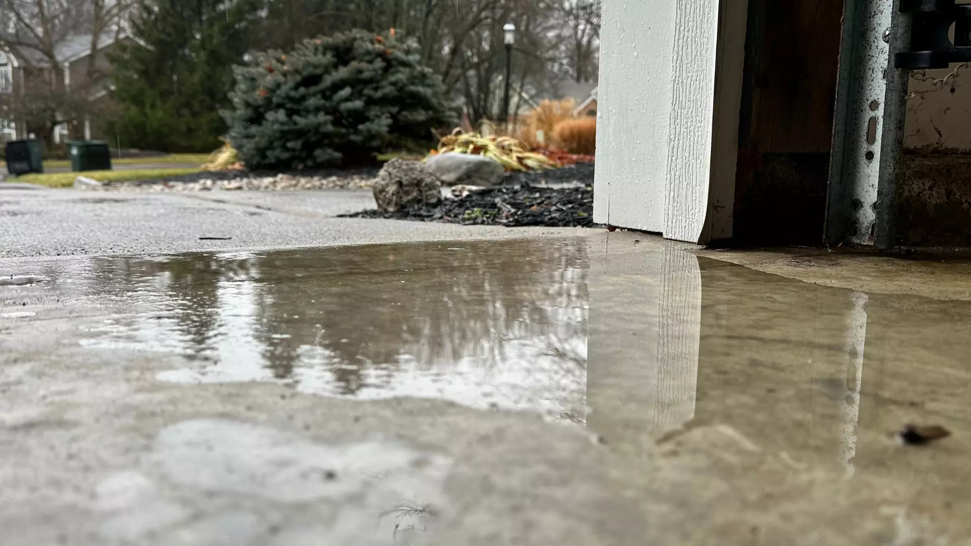Rainwater seeping under a garage door with a failed bottom weather seal